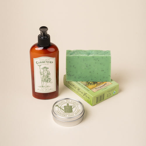 Bottle, soap bar, and tin of 'Gardeners' soap' on a beige background