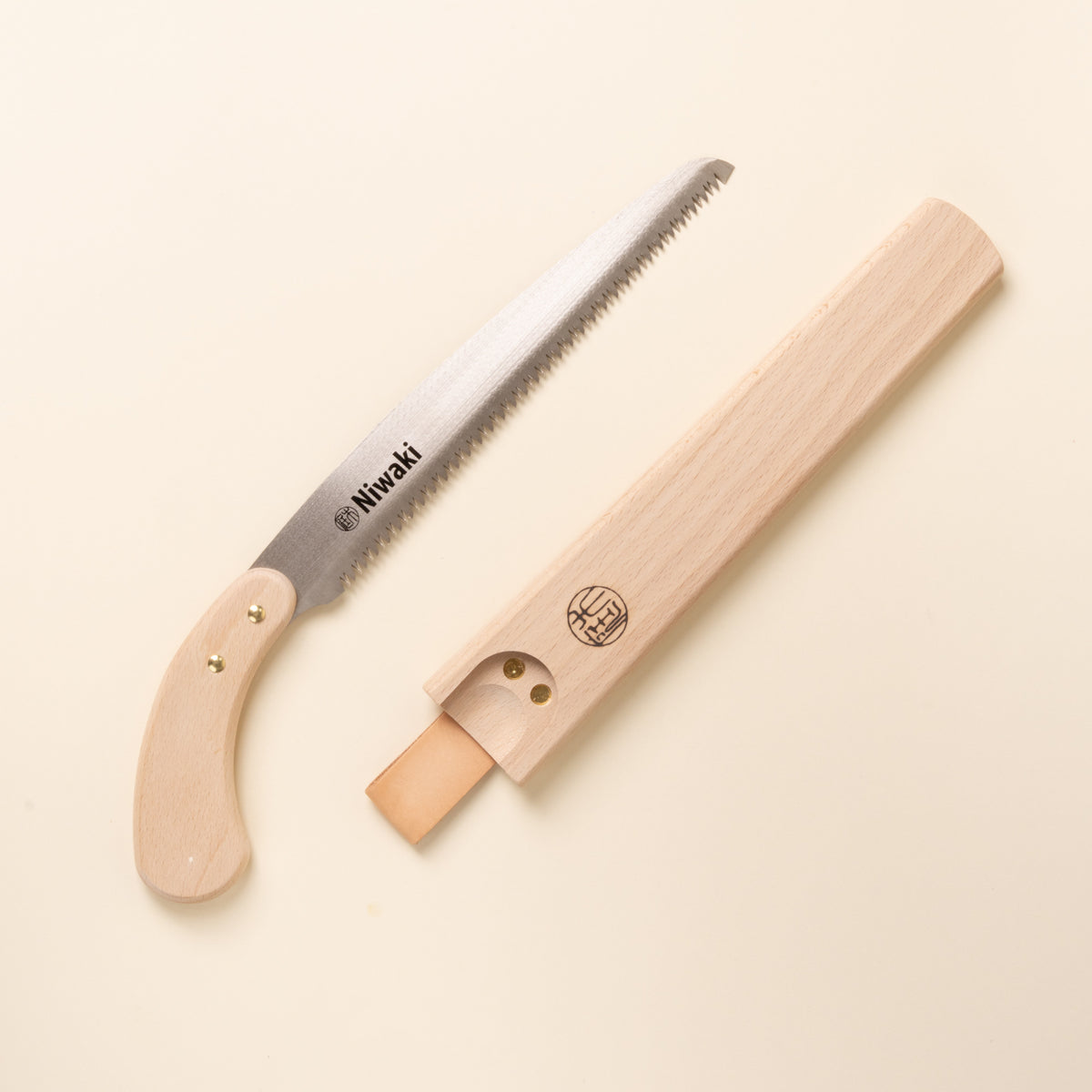 Niwaki wooden-handled pruning saw with protective wooden sheath.
