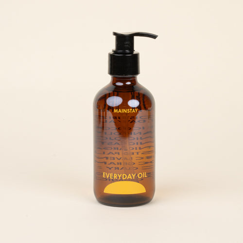 Brown bottle labeled 'Mainstay Everyday Oil' with pump on a beige background
