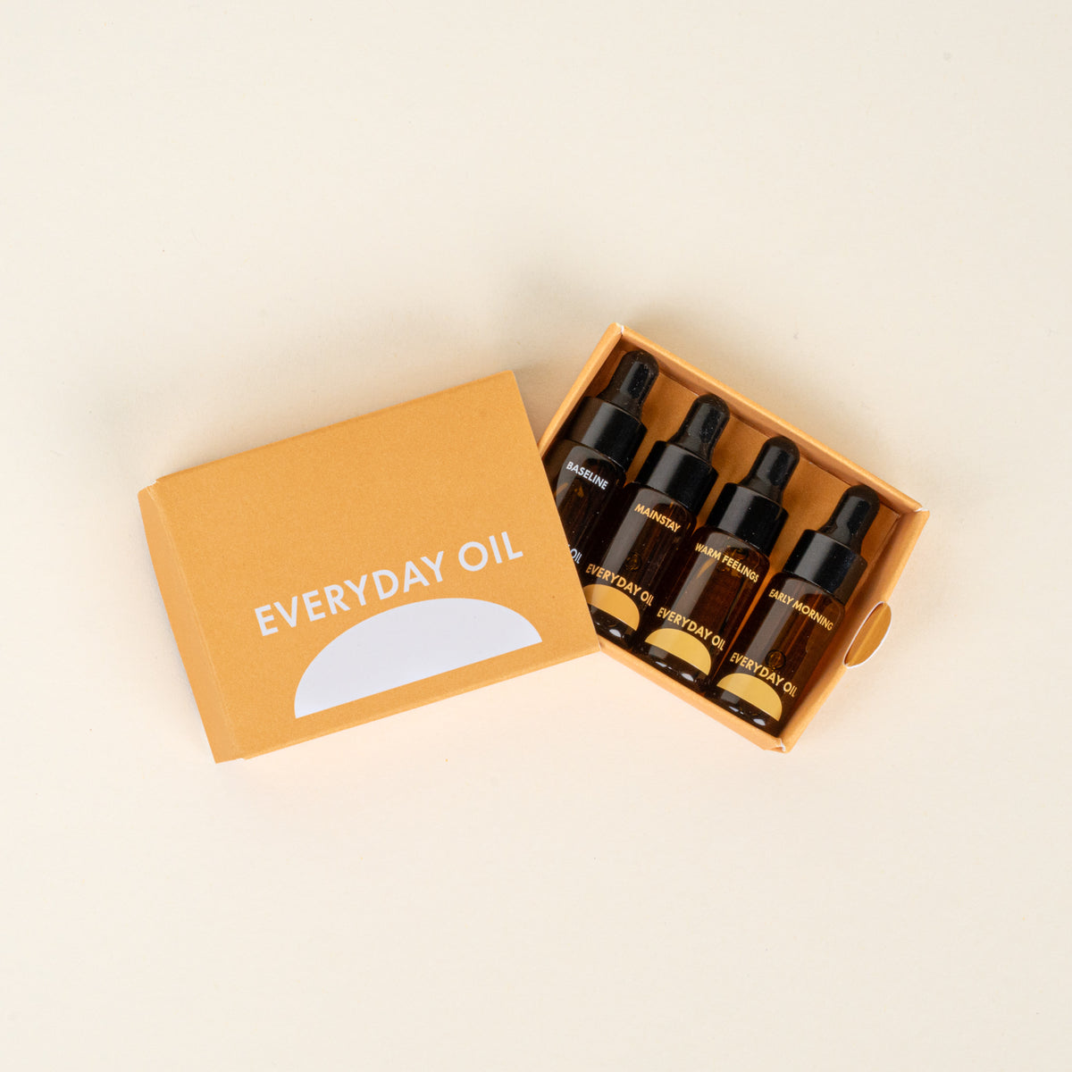 Box of 'Everyday Oil' dropper bottles on a beige background