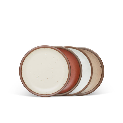 4 dessert sized ceramic plates in a cool terracotta, warm off-white, cool white, and warm pale brown color featuring iron speckles and an unglazed rim.