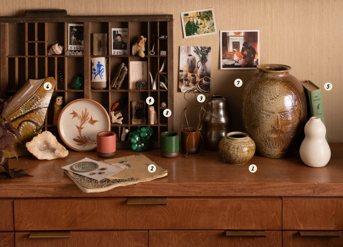 A collection of pottery, photos and small sculptural objects on a wooden surface with numbers 1-8 labeling some of the objects shown, corresponding to the numbered list below the image.