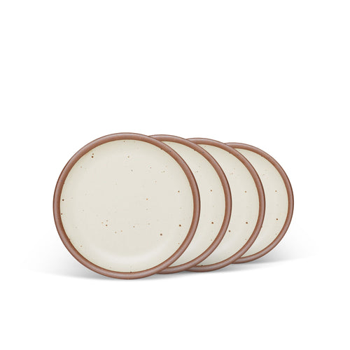 4 dessert sized ceramic plates in a warm, tan-toned, off-white color featuring iron speckles and an unglazed rim.