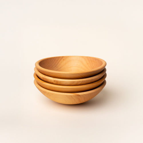 A stack of 4 small maple wood bowls