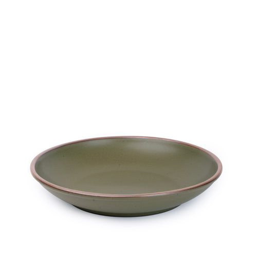A large ceramic plate with a curved bowl edge in an olive green color featuring iron speckles and an unglazed rim.