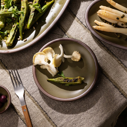 Olive-toned stoneware salad plate, styled with grilled vegetables and seasonal ingredients on a rustic linen table.