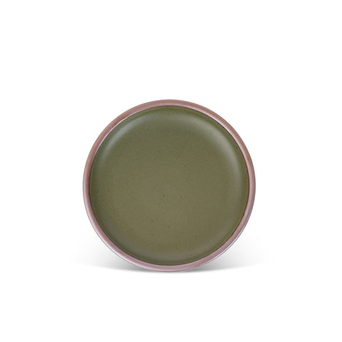 A medium sized ceramic plate in a olive green color featuring iron speckles and an unglazed rim.