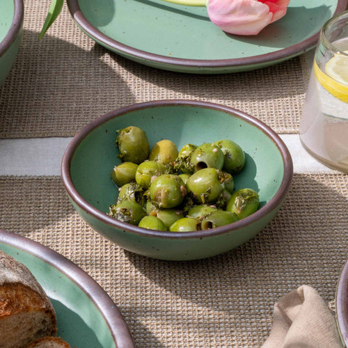 A shallow ceramic bowl for cereal or yogurt in a viridian green glaze with a matte finish.