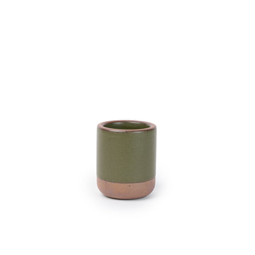 A small, short ceramic mug cup in an olive green color featuring iron speckles and unglazed rim and bottom base.