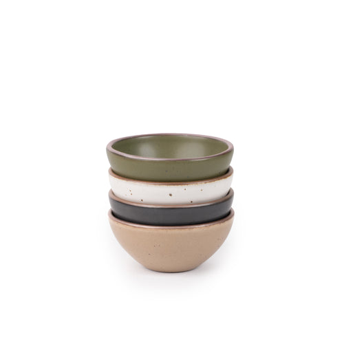 A stack of 4 small dessert sized rounded ceramic bowls in an olive green, graphite black, off-white, and warm pale brown colors featuring iron speckles and an unglazed rim
