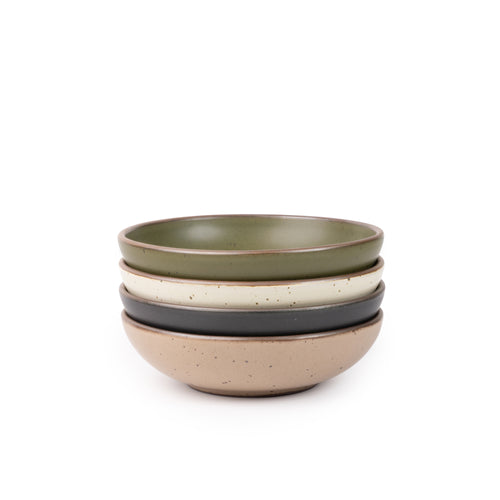 A stack of 4 dinner-sized shallow ceramic bowls in an olive green, graphite black, off-white, and pale warm brown colors featuring iron speckles and an unglazed rim