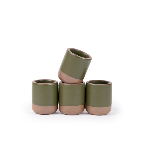 A set of 4 small, short ceramic mug cups in an olive green color featuring iron speckles and unglazed rim and bottom base, stacked in a row of 3, with the 4th on top.