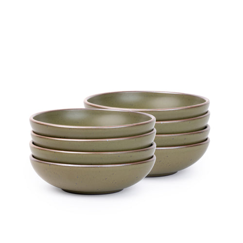 A stack of 8 dinner-sized shallow ceramic bowls in an olive green color featuring iron speckles and an unglazed rim