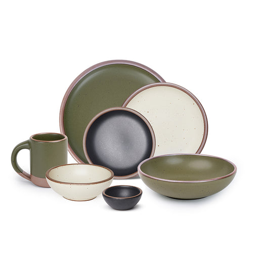 The mug, bitty bowl, breakfast bowl, everyday bowl, cake plate, side plate and dinner plate paired together in olive green, graphite black and warm off-white colors featuring iron speckles