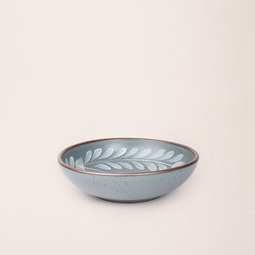 Medium ceramic shallow bowl with a hand-painted white leaf border on a blue-grey interior and exterior with an exposed clay rim.