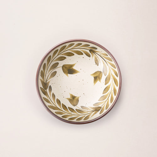 Overhead of a Medium ceramic shallow bowl with a hand-painted olive green leaf border on a cream interior and exterior with an exposed clay rim.