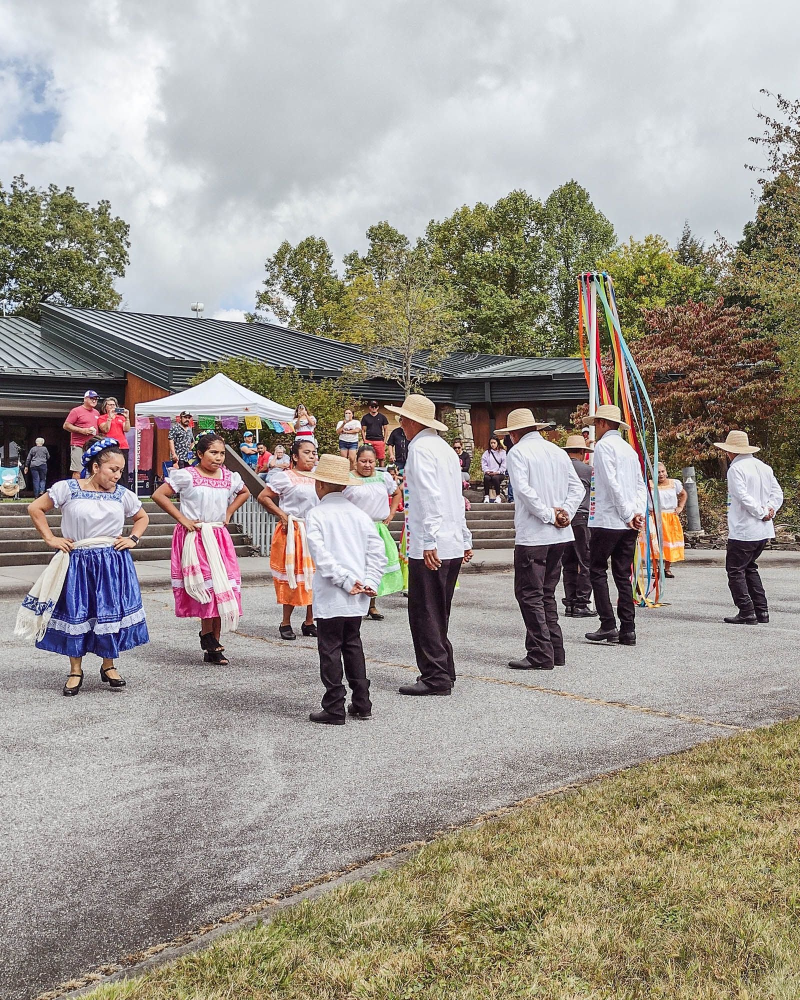 People standing in two lines facing each other and dancing at an outdoor festival