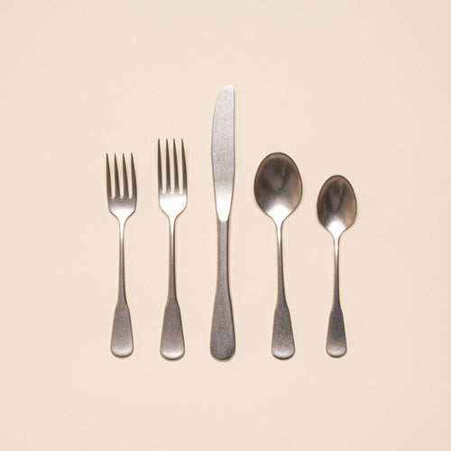 A stainless steel five-piece flatware including 2 forks, 2 spoons, and 1 knife, in a tumbled matte finish and classic design