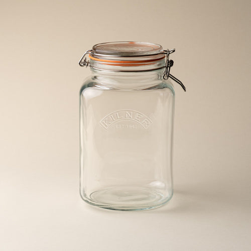 A large storage glass square jar topped with a lid with a rubber seal and steel clip closure.