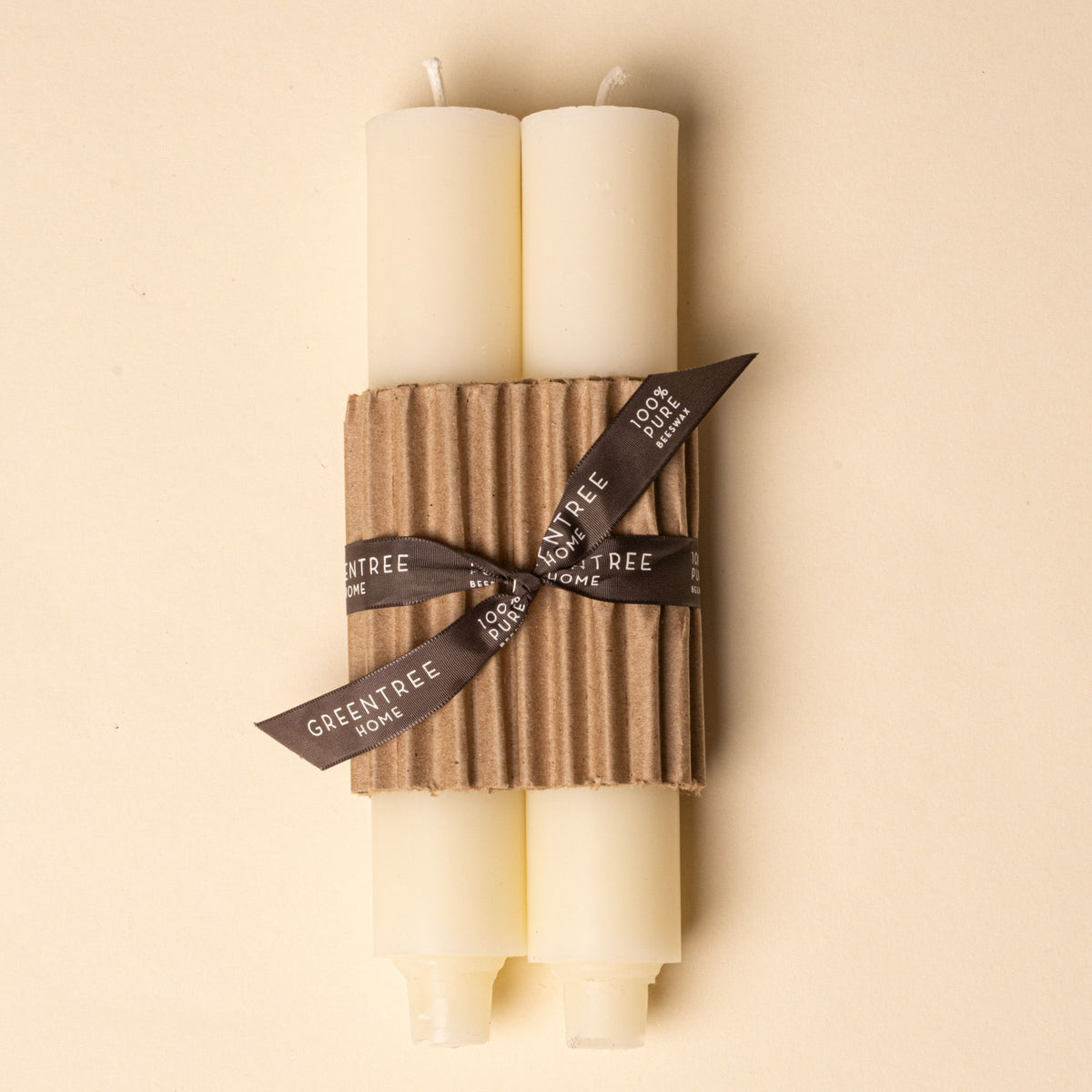 Pair of ivory pillar candles wrapped in corrugated cardboard with a brown ribbon