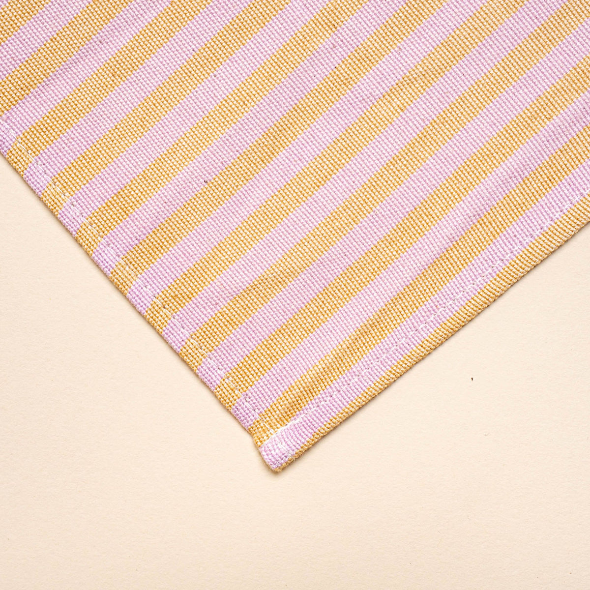A corner of a peach and pink striped napkin