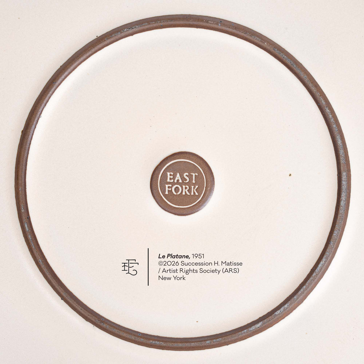 The back of the Serving Platter with an East Fork stamp with a small decal of information about the artwork.