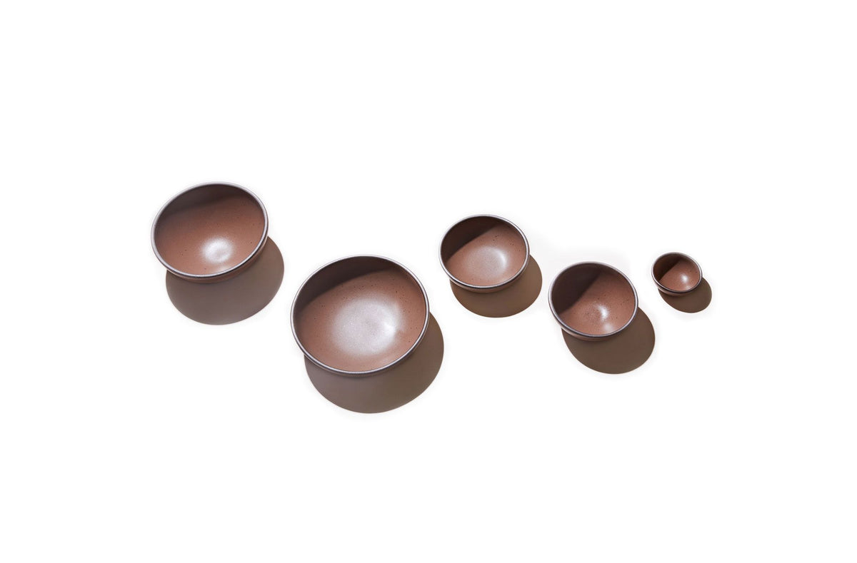 Five bowls in descending sizes all in a warm brown color against a white background.