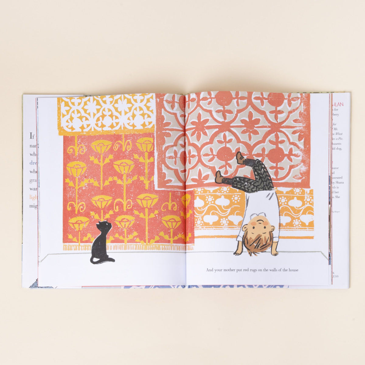 An illustrated book spread showing a child doing a handstand against a patterned red and yellow wall while a black cat watches, with text.