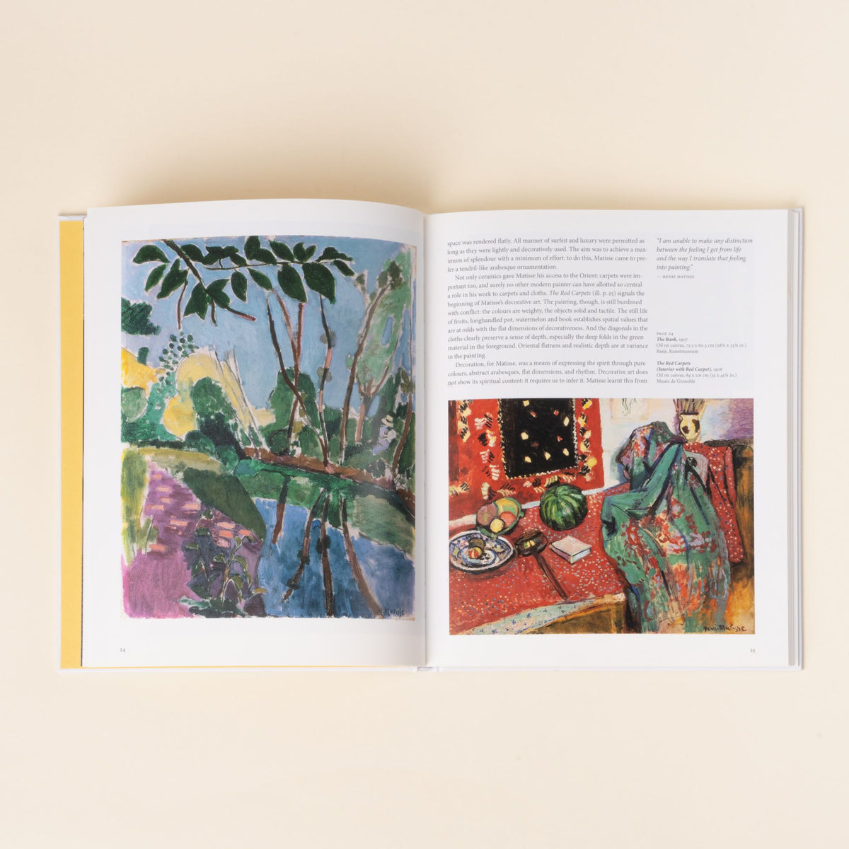 An open art book displaying colorful Henri Matisse paintings—one of a landscape and another of an interior scene with red patterned textiles.