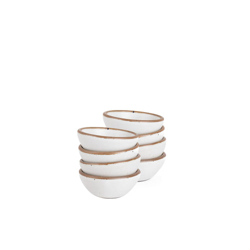 A stack of 8 tiny rounded ceramic bowls in a cool white color featuring iron speckles and an unglazed rim