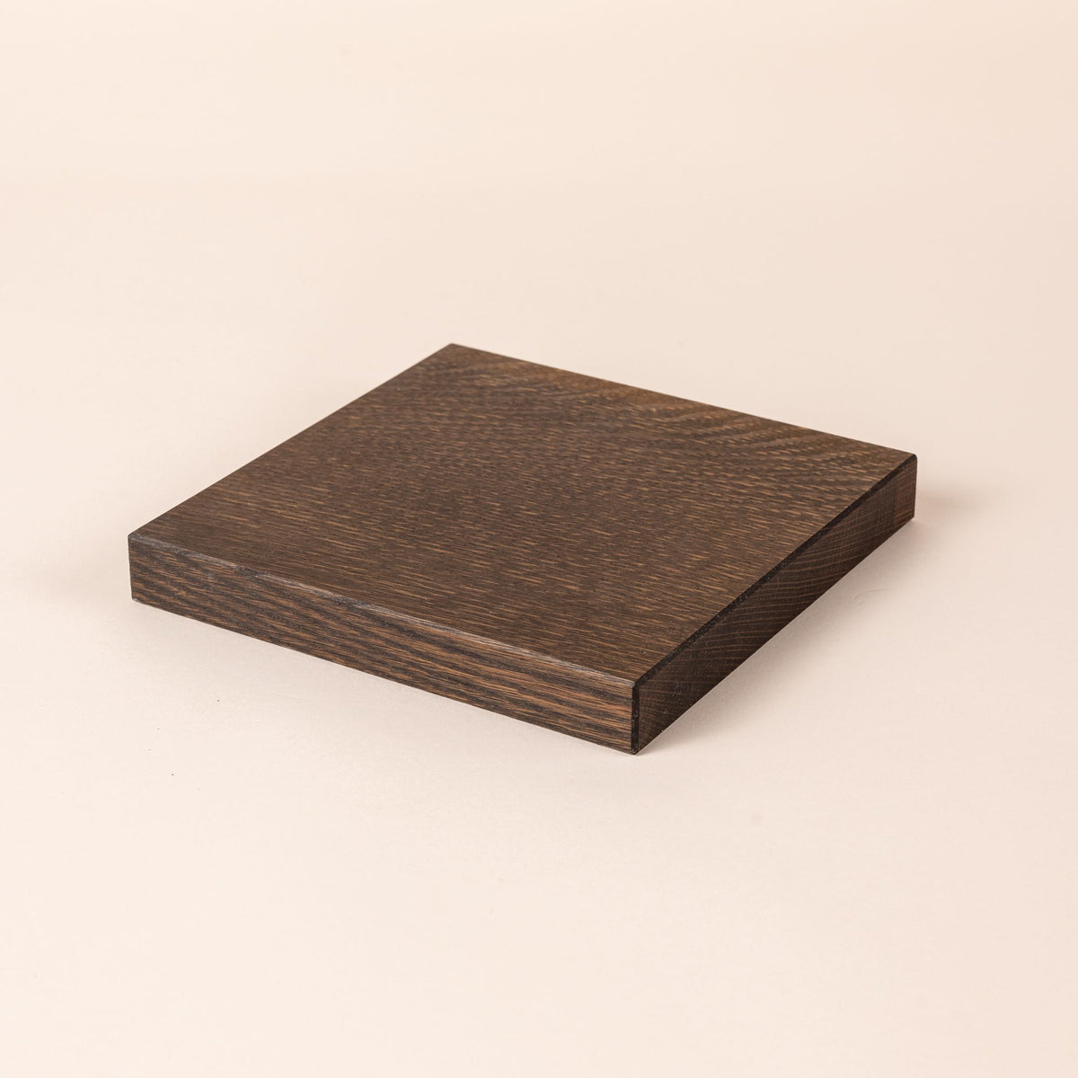 Dark wooden square board with visible grain patterns, placed on a neutral background.