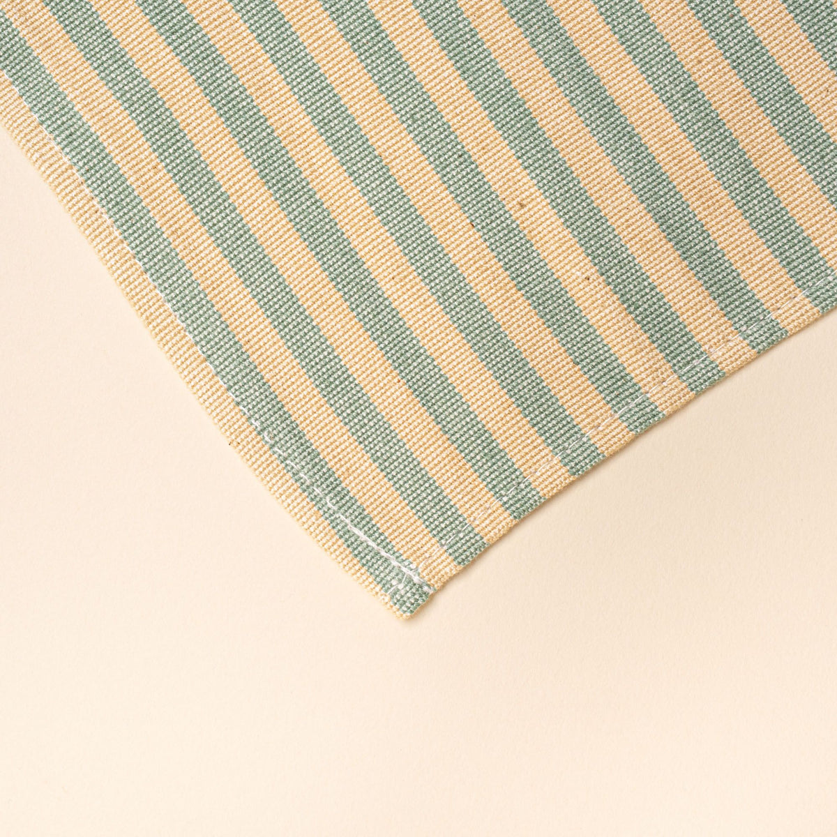A corner of a peach and green striped napkin