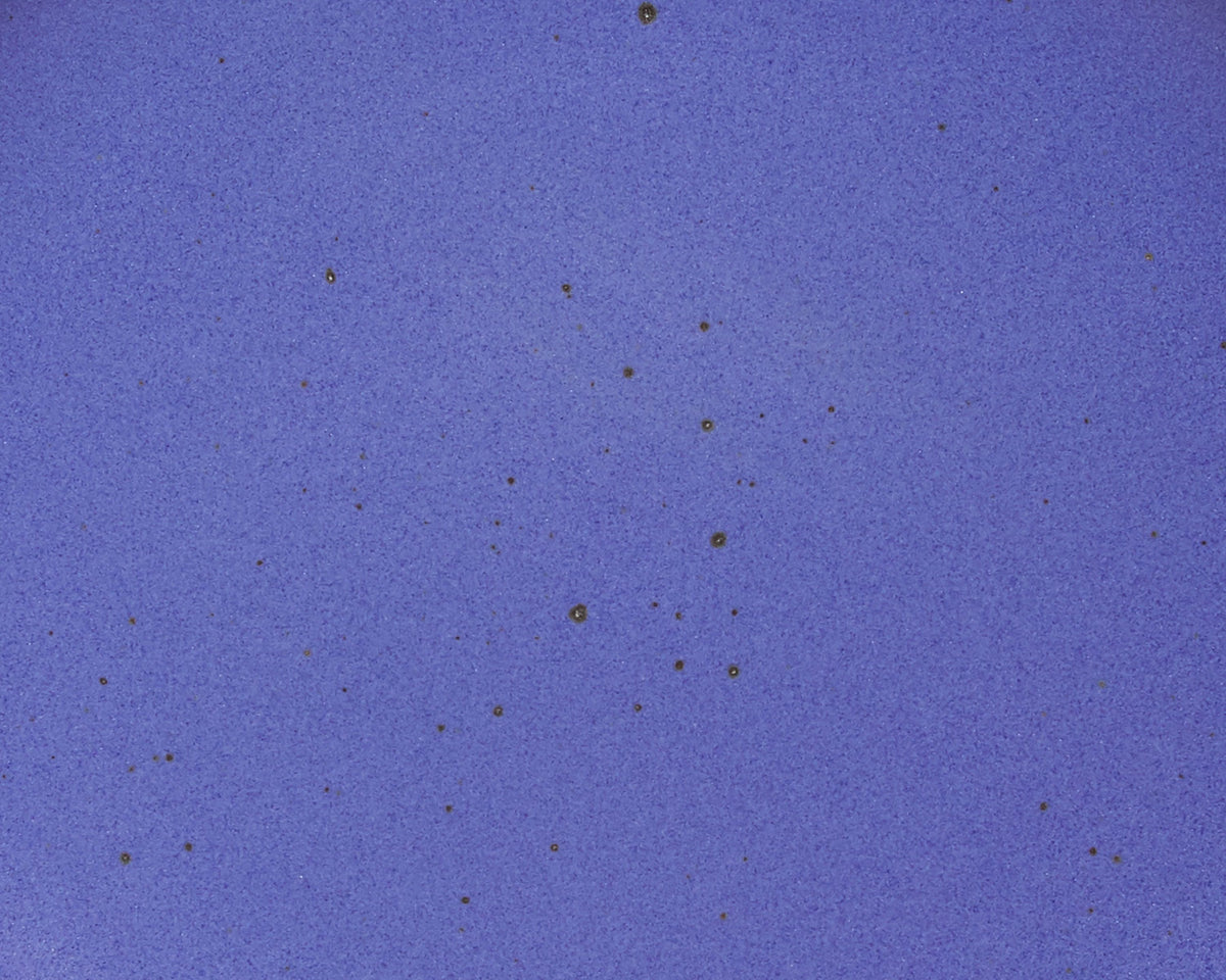 A closeup of a ceramic plate in a true cool blue color featuring iron speckles