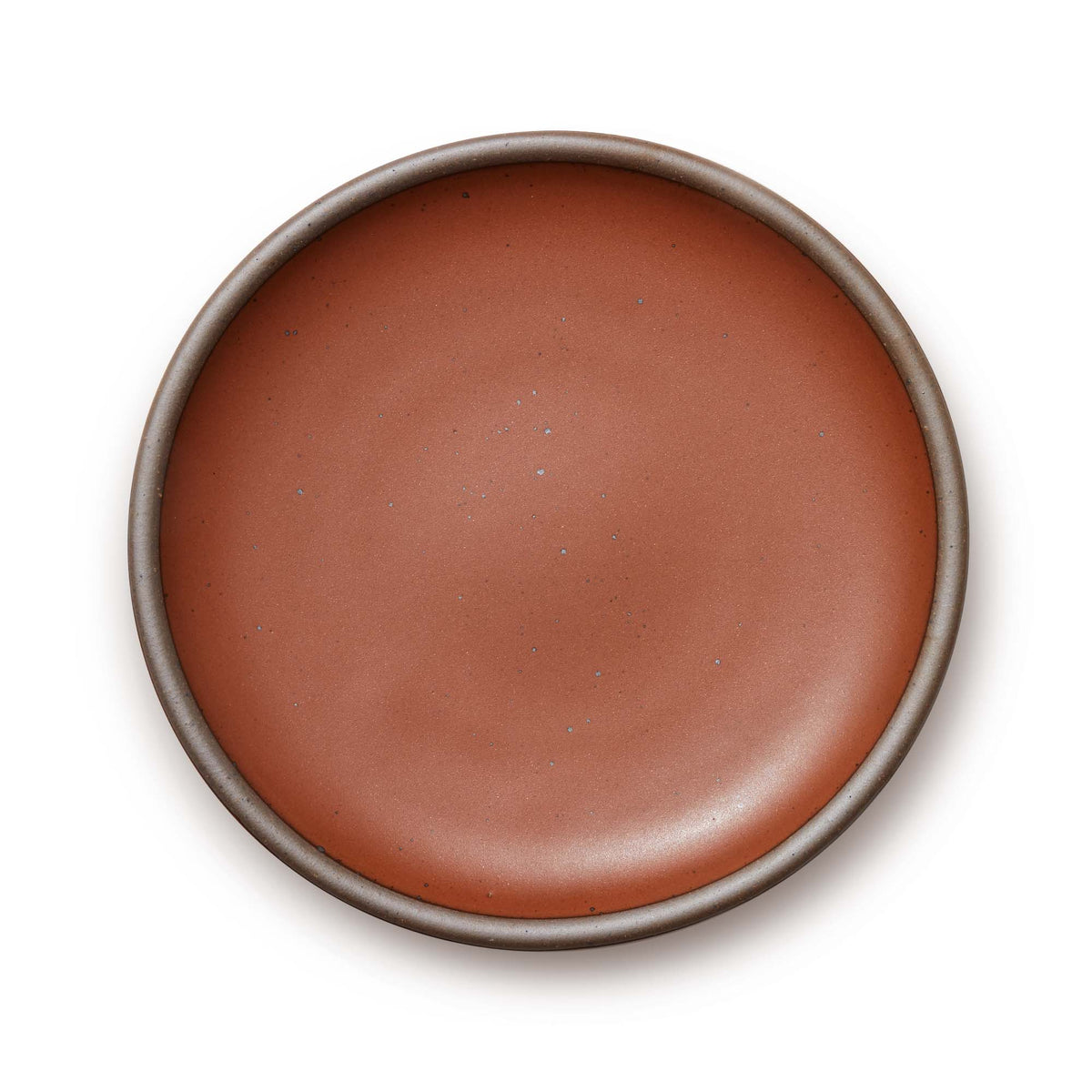 A large ceramic platter in a cool terracotta color featuring iron speckles and an unglazed rim.
