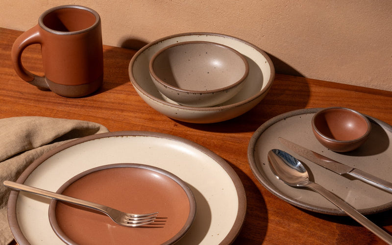 Ceramic tableware set on a wooden surface with a neutral background