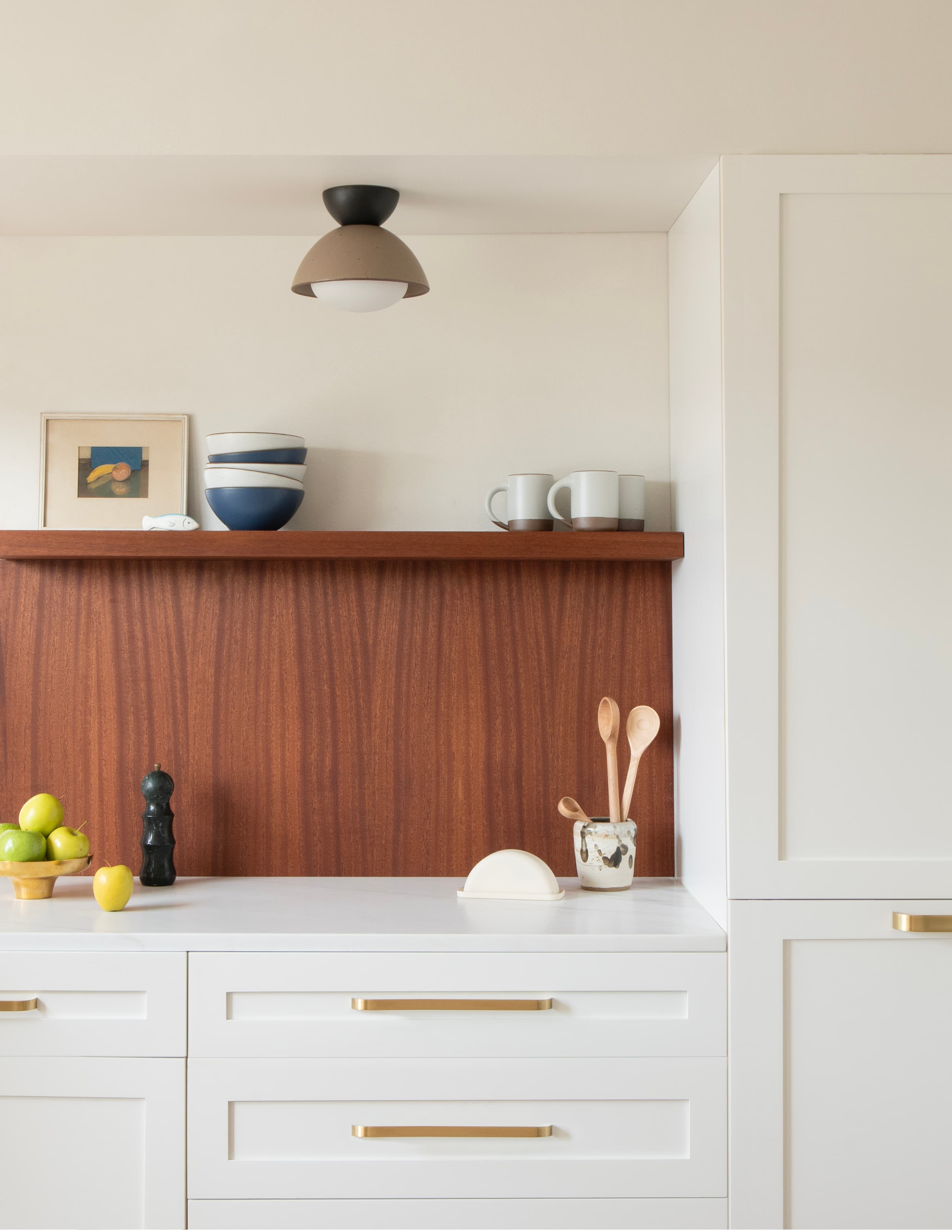 A light fixture flush-mounted to a ceiling above white kitchen cabinets