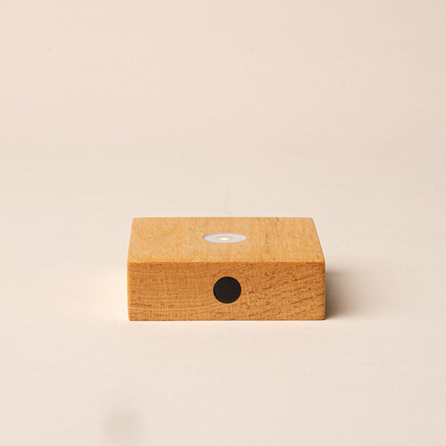 Small rectangular wooden LED light with a circular bulb on top and black button on the front.