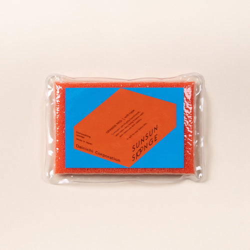 Orange-red dish sponge in clear packaging with a blue and orange Sunsun Sponge label on a light background.