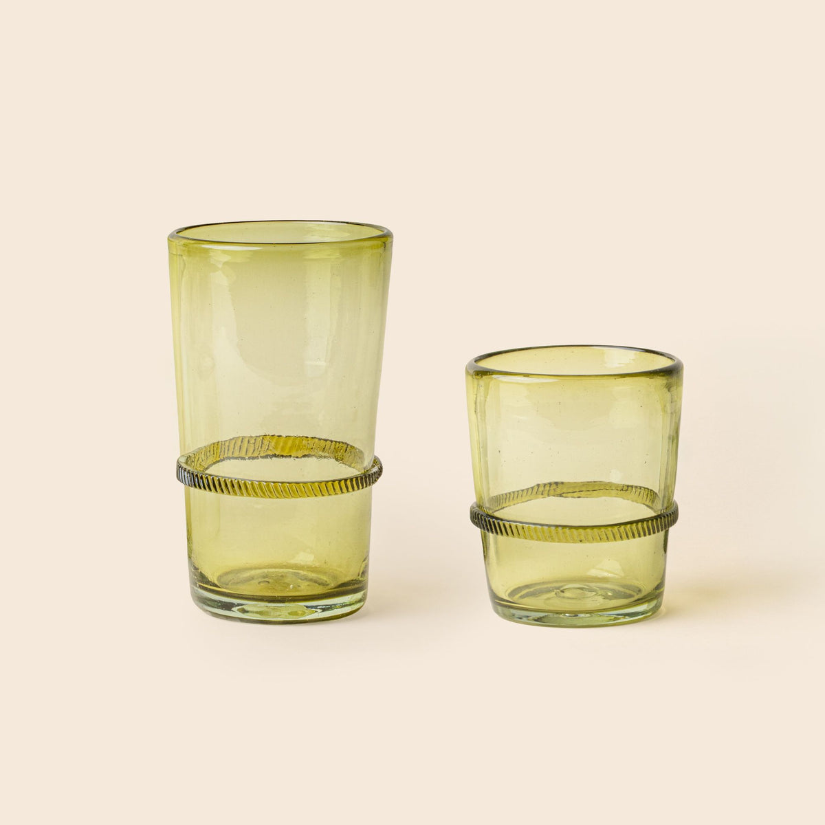 Olive green short and tall recycled glass tumblers with a ridged band detail.