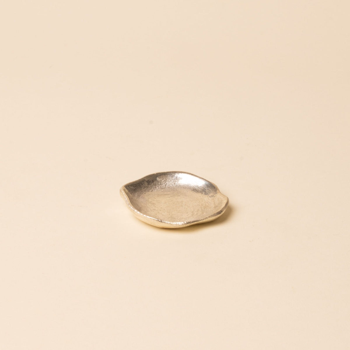 Small round chrome dish with a hammered texture, displayed on a neutral background.