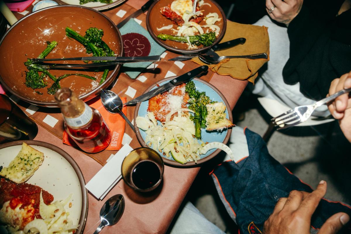 A tabletop with half eaten food on blue, brown and cream colored pots.