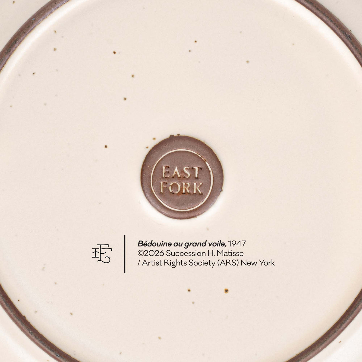 The back of a side plate with an East Fork stamp with a small decal of information about the artwork, Bédouine au grand voile, by Henri Matisse.