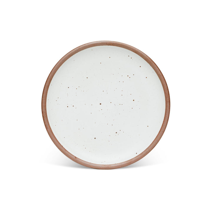 A dinner sized ceramic plate in a cool white color featuring iron speckles and an unglazed rim
