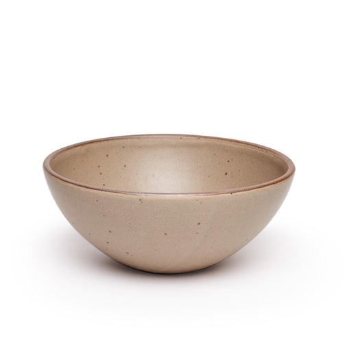 A large ceramic mixing bowl in a warm pale brown featuring iron speckles and an unglazed rim
