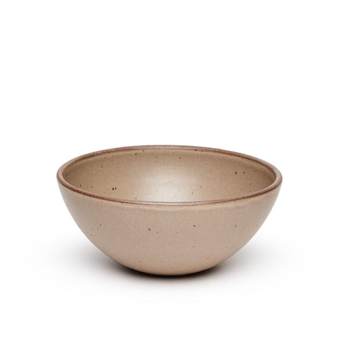 A large rounded ceramic bowl in a pale warm brown color featuring iron speckles and an unglazed rim