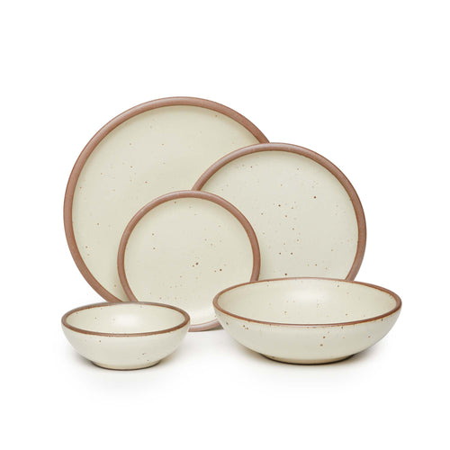 A breakfast bowl, everyday bowl, cake plate, side plate and dinner plate paired together in a warm, tan-toned, off-white featuring iron speckles